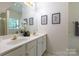 Bathroom featuring a double sink vanity, tile floors, and three decorative wall hangings at 4637 Willow Glen Rd, Harrisburg, NC 28075