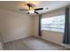 Bright bedroom with plush carpet, a ceiling fan and a window letting in natural light at 4637 Willow Glen Rd, Harrisburg, NC 28075