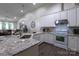 Open kitchen featuring granite countertops, white cabinetry, stainless steel appliances, and an open living space at 4637 Willow Glen Rd, Harrisburg, NC 28075