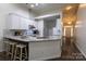 Open kitchen featuring granite countertops, white cabinetry, and bar seating connected to entry way at 4637 Willow Glen Rd, Harrisburg, NC 28075