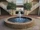 Inviting courtyard featuring a brick fountain, lush landscaping, and access to staircases in a charming community at 5003 Sharon Rd # Q, Charlotte, NC 28210