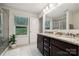 Stylish bathroom with a granite countertop, glass shower, and a view of trees through the window at 5113 Saddleback Dr, Mount Holly, NC 28120