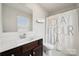 Bright bathroom featuring a modern vanity, mirror, and a shower with decorative curtain at 5113 Saddleback Dr, Mount Holly, NC 28120