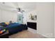Bedroom with ceiling fan, window, plush blue bedding, and a large black dresser at 5113 Saddleback Dr, Mount Holly, NC 28120