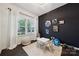 Bright bedroom featuring dark accent wall, hardwood floors, and natural light at 5113 Saddleback Dr, Mount Holly, NC 28120