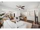 Open concept living room with a ceiling fan and dark wood flooring, seamlessly flowing into the kitchen and staircase at 5113 Saddleback Dr, Mount Holly, NC 28120