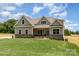 Beautiful new home has a covered porch with stone accents and a well-maintained front lawn at 5408 Unionville Brief Rd, Unionville, NC 28110