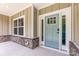 Stylish light-blue front door with sidelights and modern hardware, complemented by stone accents and landscaping at 5408 Unionville Brief Rd, Unionville, NC 28110