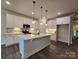 Modern kitchen with a center island, pendant lighting, stainless steel appliances, and white cabinetry at 5408 Unionville Brief Rd, Unionville, NC 28110