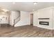 Cozy living room featuring a modern fireplace, hardwood floors, and staircase at 5408 Unionville Brief Rd, Unionville, NC 28110