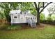 Back exterior view of a charming home with stairs leading to the lush backyard and mature trees at 616 N Deal Ave, Newton, NC 28658