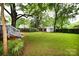 Expansive backyard with a lush green lawn, mature trees, and a charming storage shed at 616 N Deal Ave, Newton, NC 28658