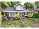 Charming two-story home with a welcoming front porch, vibrant red door, and lush landscaping at 616 N Deal Ave, Newton, NC 28658