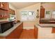 Cozy kitchen with a microwave, hardwood floors, and charming floral valances at 616 N Deal Ave, Newton, NC 28658