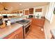 A sunlit kitchen with a stainless steel range, hardwood floors, and delightful floral valances at 616 N Deal Ave, Newton, NC 28658