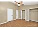Bedroom with ceiling fan, two closets, and wood-look floors, offering ample storage space at 6401 Windsor Gate Ln, Charlotte, NC 28215