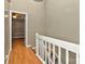 Hallway with wood-look flooring and white railing, providing a seamless transition to the next room at 6401 Windsor Gate Ln, Charlotte, NC 28215