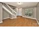 Bright living room features wood floors, staircase, and natural light from the large window at 6401 Windsor Gate Ln, Charlotte, NC 28215