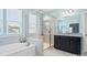 Bright bathroom featuring a soaking tub, glass shower, and modern vanity with granite countertops at 6535 Bridgemoor Dr, Indian Trail, NC 28079