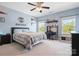 Bedroom with blue painted walls, decor, ceiling fan, bed with decorative pillows, and natural light at 6535 Bridgemoor Dr, Indian Trail, NC 28079