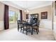 Formal dining room with black wood table set, decor, and large window with bright natural light and neutral paint at 6535 Bridgemoor Dr, Indian Trail, NC 28079