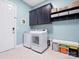 Functional laundry room with modern washer and dryer, storage cabinets, and a utility sink at 6535 Bridgemoor Dr, Indian Trail, NC 28079