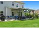 Back exterior view of covered patio with black wooden frame, comfortable seating, and backyard at 6535 Bridgemoor Dr, Indian Trail, NC 28079