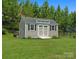 A shed in the backyard with gray siding, a black roof, and black shutters at 6535 Bridgemoor Dr, Indian Trail, NC 28079