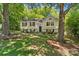Traditional two-story home with light siding nestled among mature trees and a manicured front yard at 7018 Rollingridge Dr, Charlotte, NC 28211