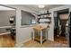 Kitchen pass-through to living room with butcher block island and open shelving for storage at 7018 Rollingridge Dr, Charlotte, NC 28211