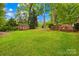 Large grassy backyard with a storage shed and a deck, perfect for outdoor activities and relaxation at 7022 Lakeside Dr, Charlotte, NC 28215