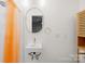 Bathroom featuring modern vanity, a round mirror, and an orange shower curtain at 7022 Lakeside Dr, Charlotte, NC 28215