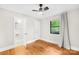 Bedroom with hardwood floors, ceiling fan and a glimpse into an adjacent bathroom at 7022 Lakeside Dr, Charlotte, NC 28215