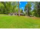 Well-maintained single-story home with a lush green lawn and mature trees, providing a serene and inviting atmosphere at 7022 Lakeside Dr, Charlotte, NC 28215