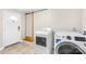 Well-equipped laundry room with tile floors, modern washer and dryer, and convenient access to the exterior at 7022 Lakeside Dr, Charlotte, NC 28215