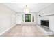 Cozy living room with a white-painted brick fireplace and tile floors at 7022 Lakeside Dr, Charlotte, NC 28215