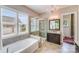 Luxurious bathroom with a soaking tub, a glass shower, and dual vanities with granite countertops at 8070 Clems Branch Rd, Indian Land, SC 29707