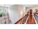 Hallway with hardwood floors, elegant lighting, and decorative wrought iron banister at 8070 Clems Branch Rd, Indian Land, SC 29707