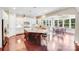 Open kitchen and breakfast nook with hardwood floors and lots of natural light from surrounding windows at 8070 Clems Branch Rd, Indian Land, SC 29707