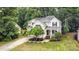 Aerial view of home featuring lush landscaping, a long driveway, and mature trees creating a private and serene setting at 8256 Chatham Oaks Dr, Concord, NC 28027