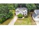 Aerial view of a well-maintained home with lush landscaping, a long driveway, and mature trees creating a private setting at 8256 Chatham Oaks Dr, Concord, NC 28027