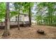 Beautiful backyard with a fire pit, split rail fence, and mature trees surrounding the property at 8256 Chatham Oaks Dr, Concord, NC 28027