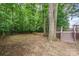 Backyard with a fire pit, a split rail fence, and a wooded backdrop with mature trees at 8256 Chatham Oaks Dr, Concord, NC 28027