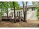 Spacious backyard featuring a large deck and a fire pit, surrounded by trees at 8256 Chatham Oaks Dr, Concord, NC 28027