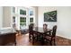 Dining room with large windows and hardwood floors; vintage chairs surround a wooden table with decorative painting on the wall at 8256 Chatham Oaks Dr, Concord, NC 28027