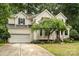 Well-manicured lawn leads up to the home's front exterior, showcasing its architectural features and mature landscaping at 8256 Chatham Oaks Dr, Concord, NC 28027