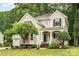 Charming home with a landscaped front yard, covered porch, and inviting curb appeal nestled amongst mature trees at 8256 Chatham Oaks Dr, Concord, NC 28027