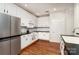 Bright kitchen with white cabinets, black countertops, stainless steel refrigerator, and hardwood flooring at 8256 Chatham Oaks Dr, Concord, NC 28027