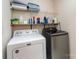 Bright laundry room with washer, dryer, shelves and cleaning supplies at 8256 Chatham Oaks Dr, Concord, NC 28027