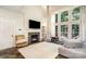 Spacious living room with soaring ceilings, a cozy fireplace, and large windows providing abundant natural light at 8256 Chatham Oaks Dr, Concord, NC 28027